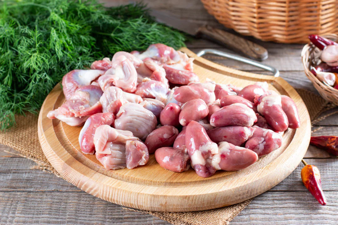 uncooked chicken giblets on a wooden board | Herb Fed Poultry