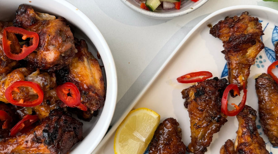A bowl of sticky hot honey chicken wings topped with fresh red chilli | Herb Fed Poultry