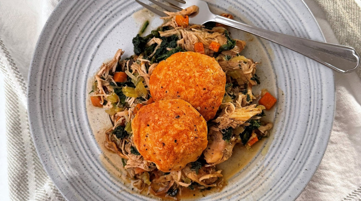 Chicken cobbler with two golden cheddar scones on a bed of shredded chicken and vegetables | Herb Fed Poultry