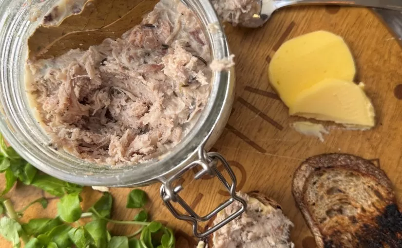 A glass jar filled with Herb Fed Chicken Rillettes on board with butter and sourdough | Herb Fed Poultry