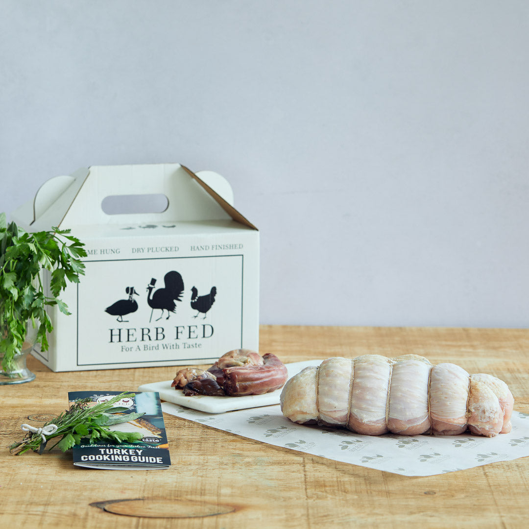 Butchered turkey on a wooden table with packaging and a cooking guide | Herb Fed Poultry