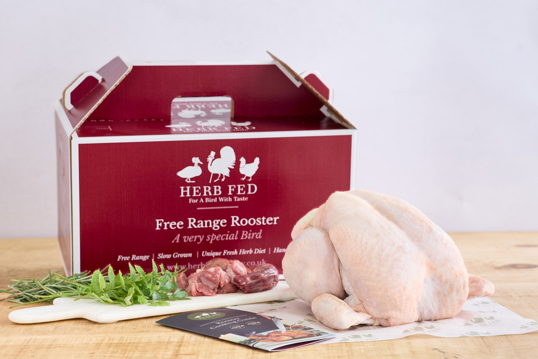 A Christmas rooster beside cardboard packaging | Herb Fed Poultry