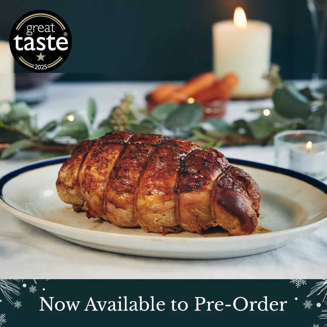 Roasted dish on a plate with candles and greenery, featuring the Great Taste logo | Herb Fed