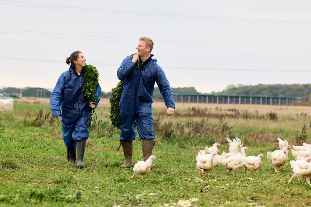 edward and emma feeding the chickens outdoors